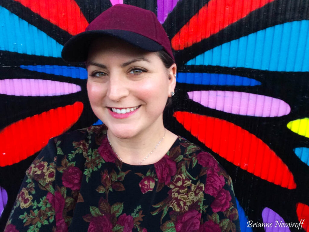 Brianne Nemiroff of It's Bree and Ben posing in front of street art in Pittsburgh